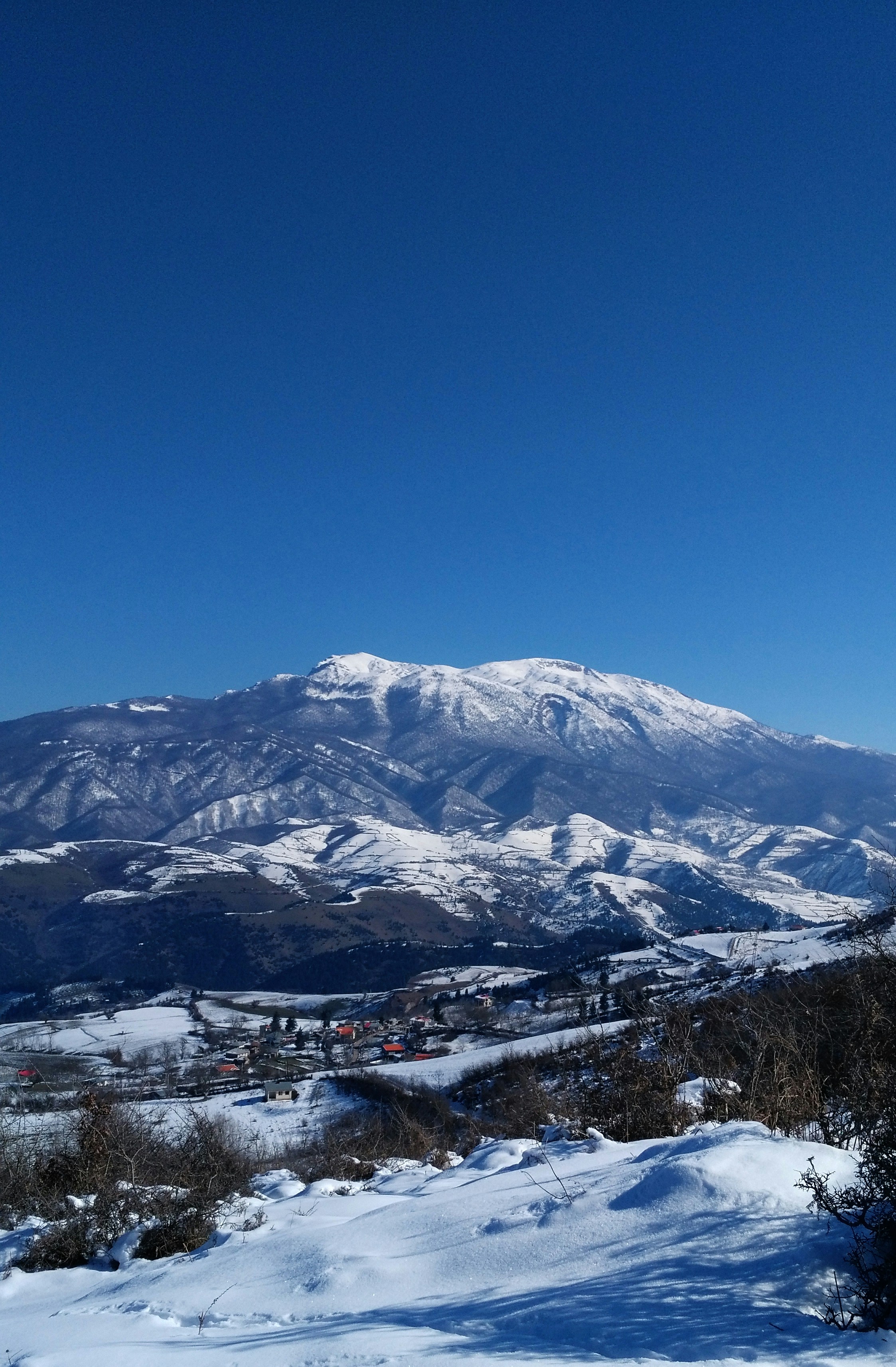 A view of a snowy mountain range from a distance