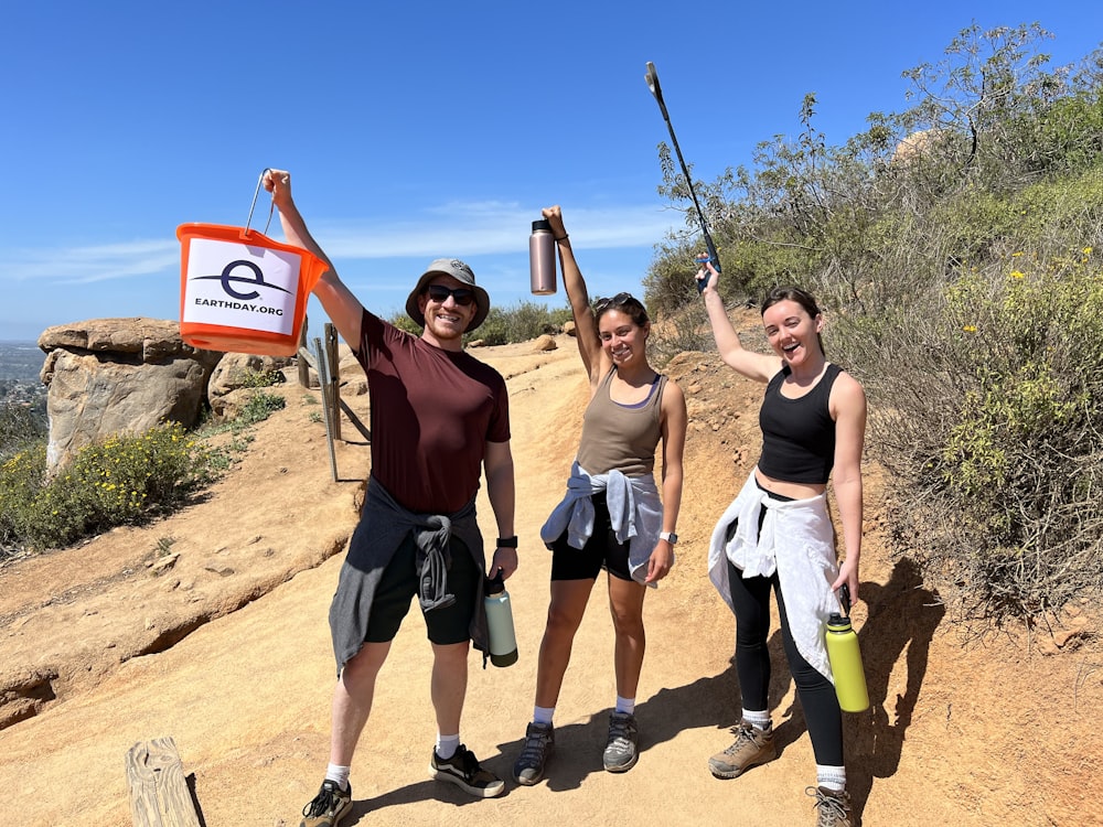 a group of women standing on top of a dirt hill