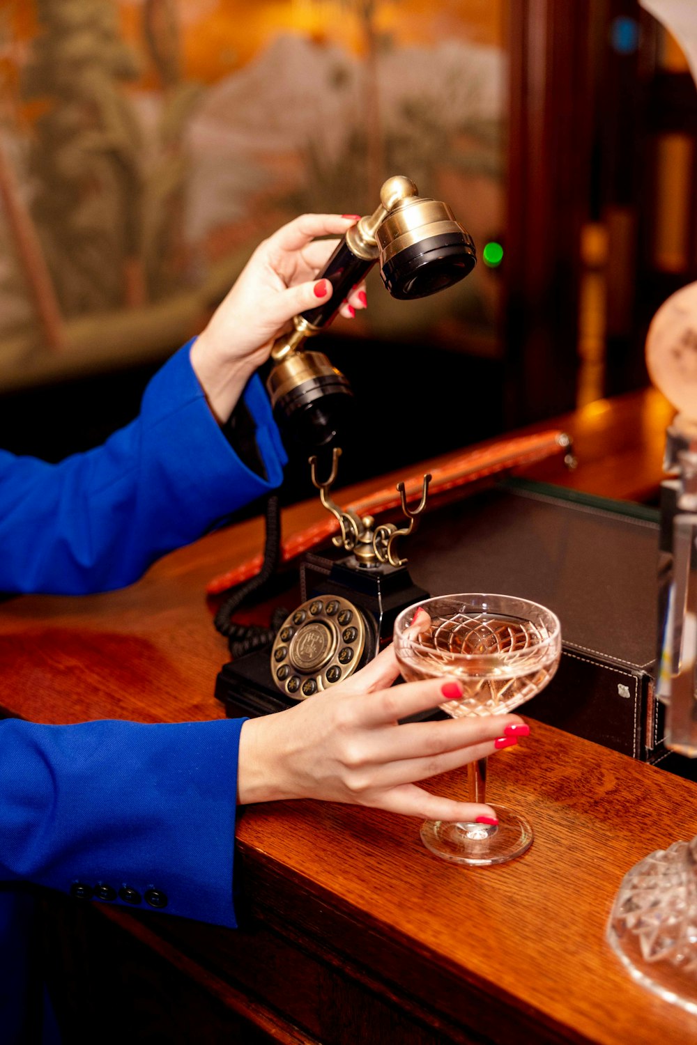 Una donna seduta in un bar con un bicchiere di vino