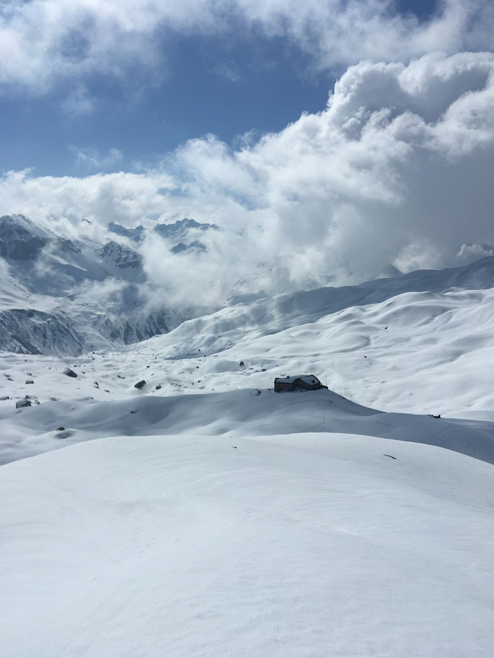 Una persona montando esquís en la cima de una pendiente cubierta de nieve