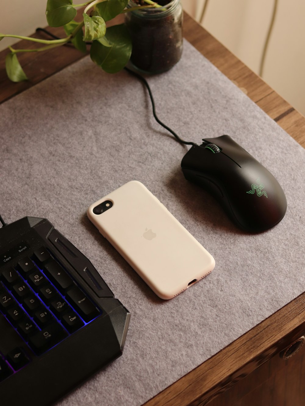 a computer mouse, keyboard, and phone on a table