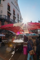 A sunny marketplace scene with people enjoying gourmet food.