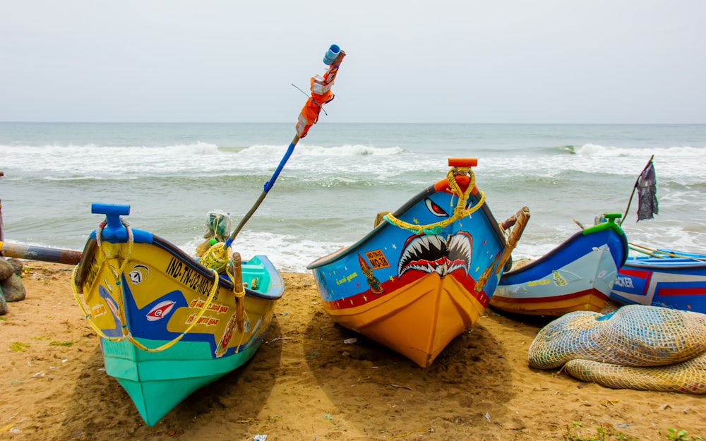 a group of boats sitting on top of a sandy beach