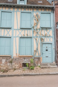 A Yorkshire terraced house freshly painted in soft cream with neat blue shutters.