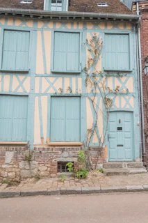 Exterior view of a renovated Saint Malo townhouse showcasing fresh paint and restored shutters.