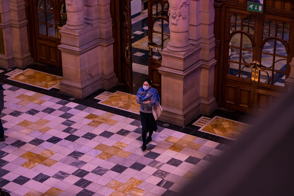 Un hombre parado en un piso a cuadros frente a un edificio