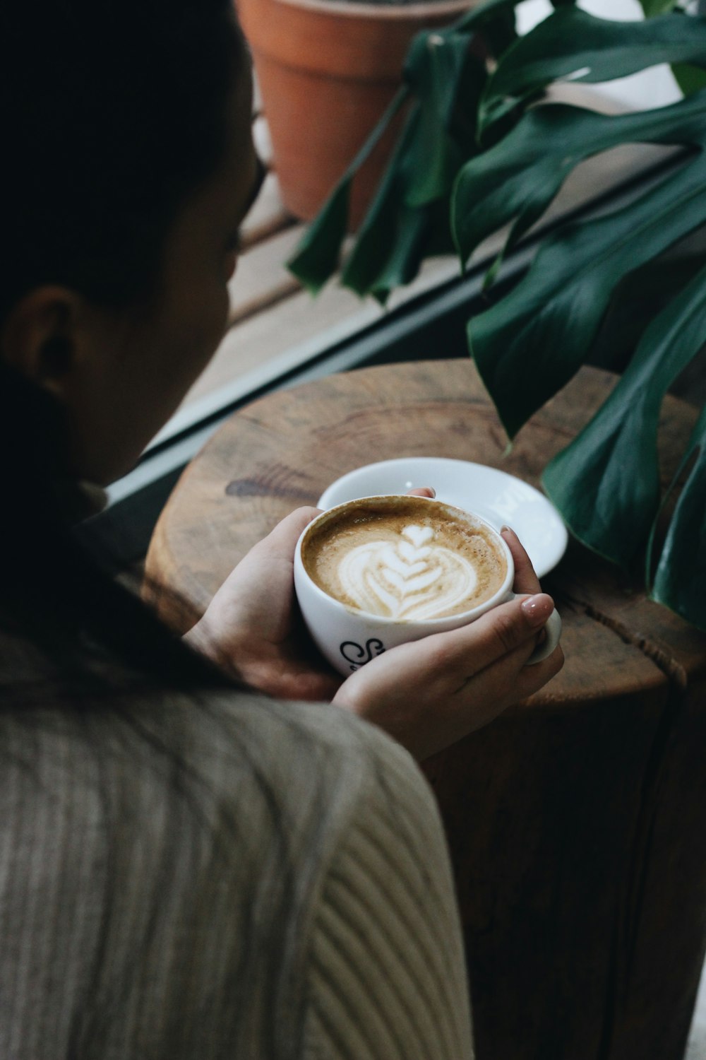 a woman is holding a cup of coffee