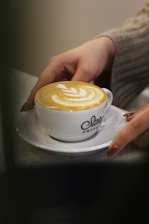 Hands of a woman and advisor discussing paperwork over coffee