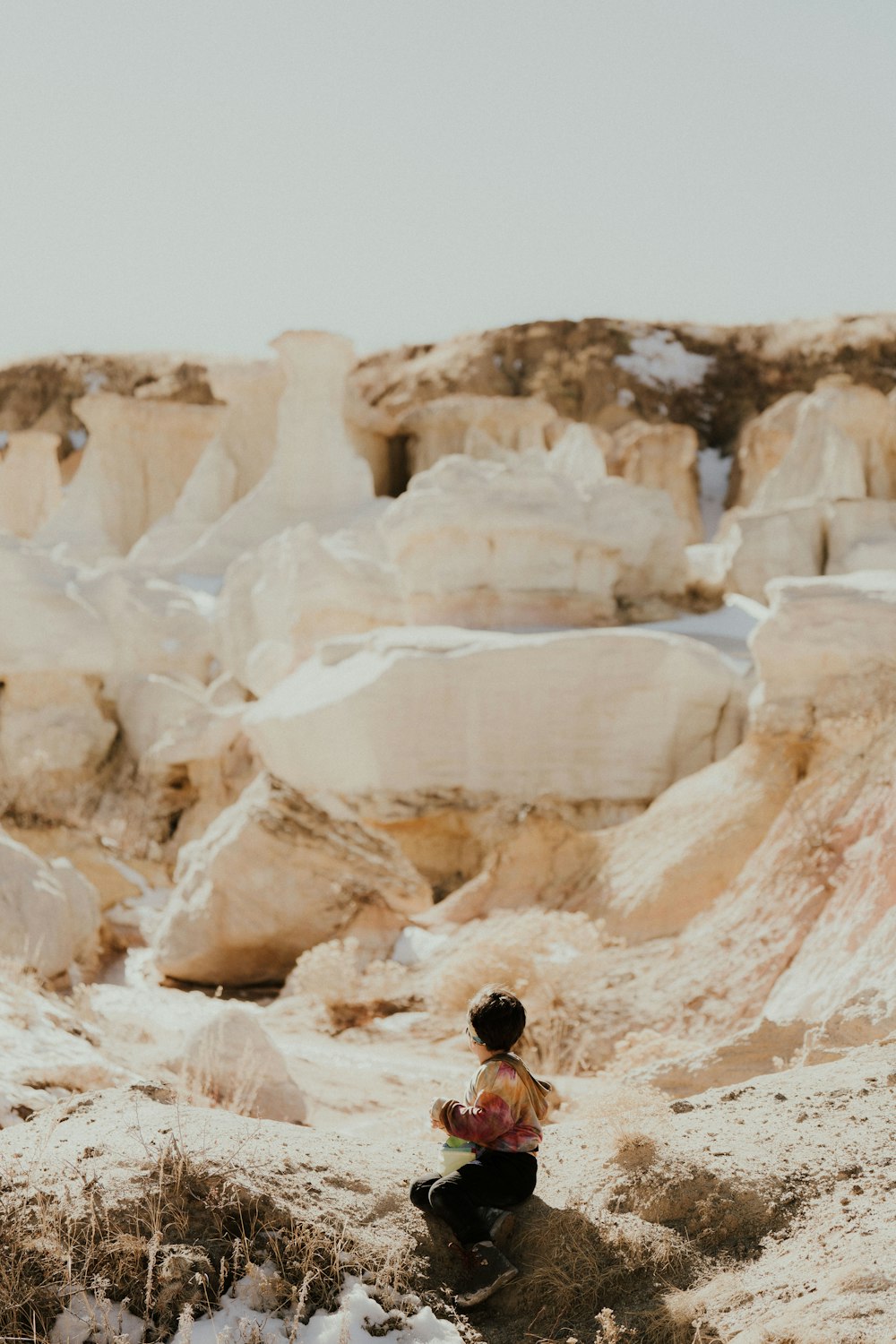 a person sitting on a rock in the desert