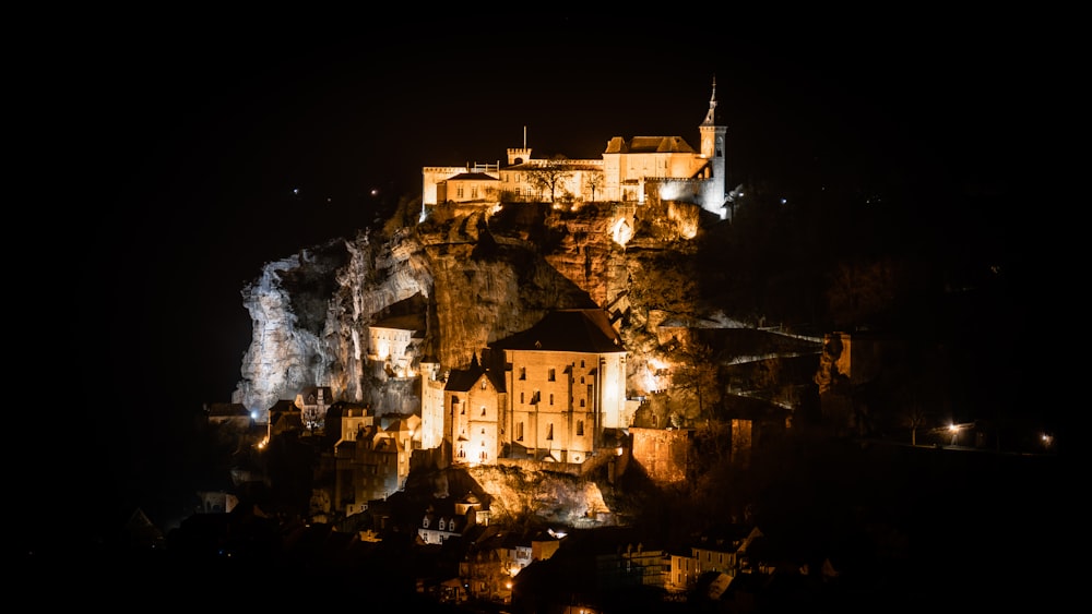 a castle lit up at night on a hill