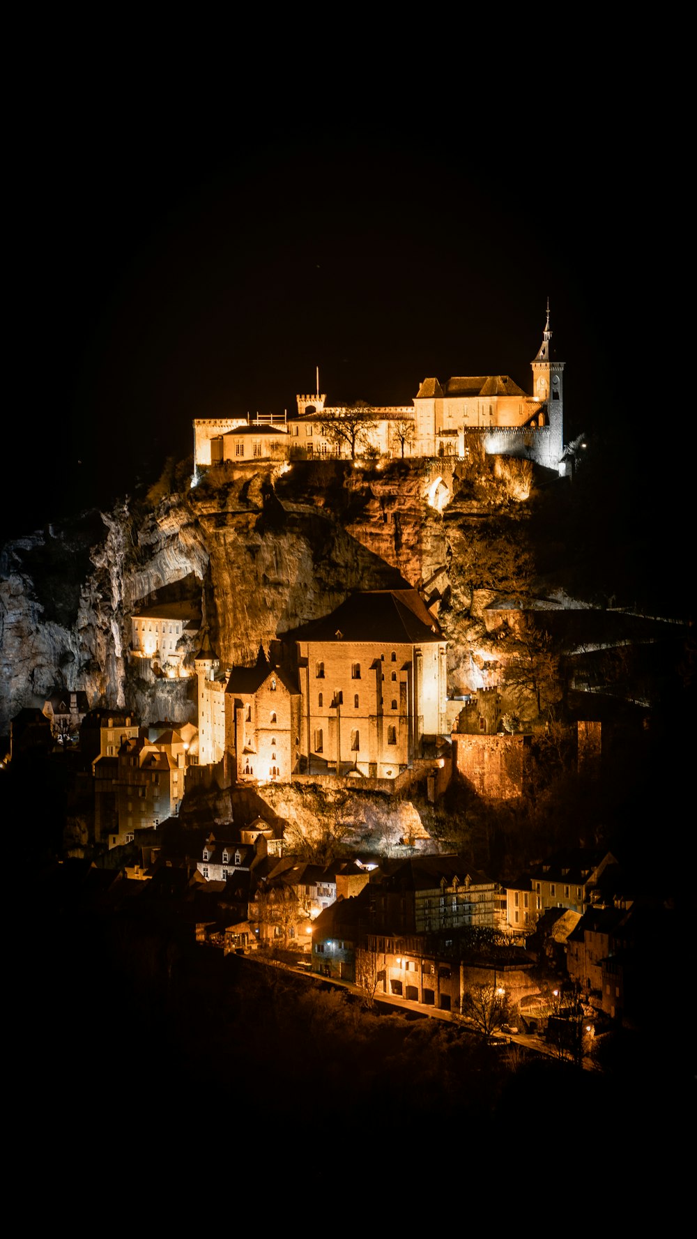 a castle lit up at night on top of a hill