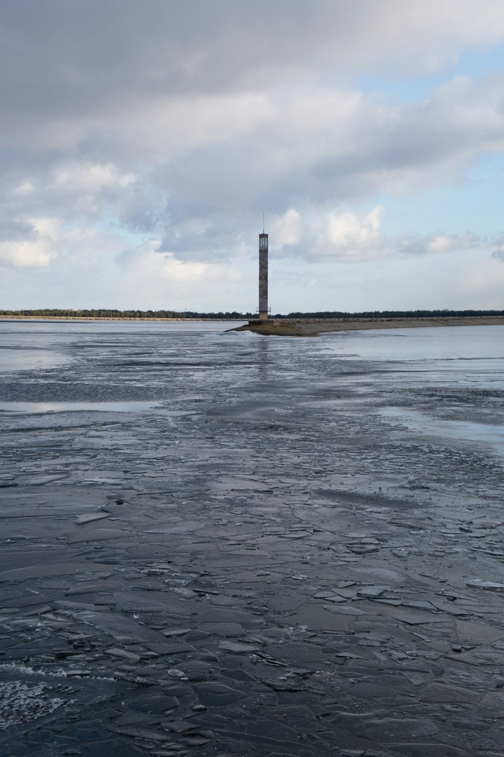 a large body of water with a light house in the distance