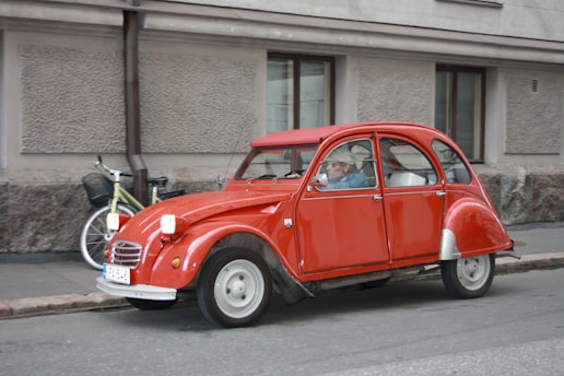 Front view of a red Citroën C3 parked on a city street.