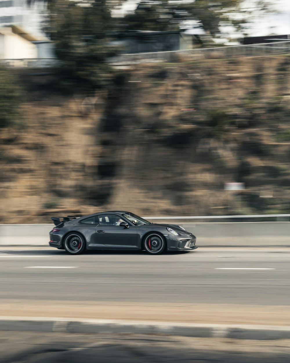 a black sports car driving down the road