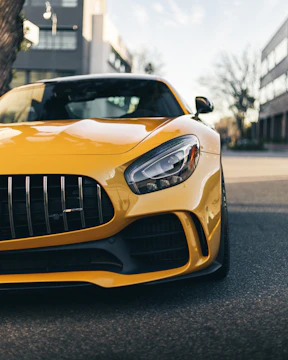 Close-up shot of a sleek black Ford Mustang with a newly designed front splitter in an urban setting.