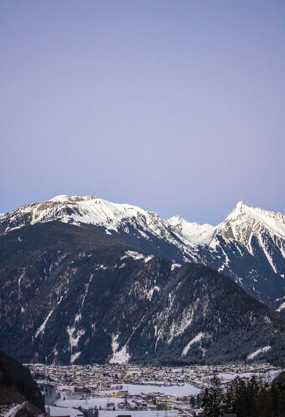 a snowy mountain range with a town below