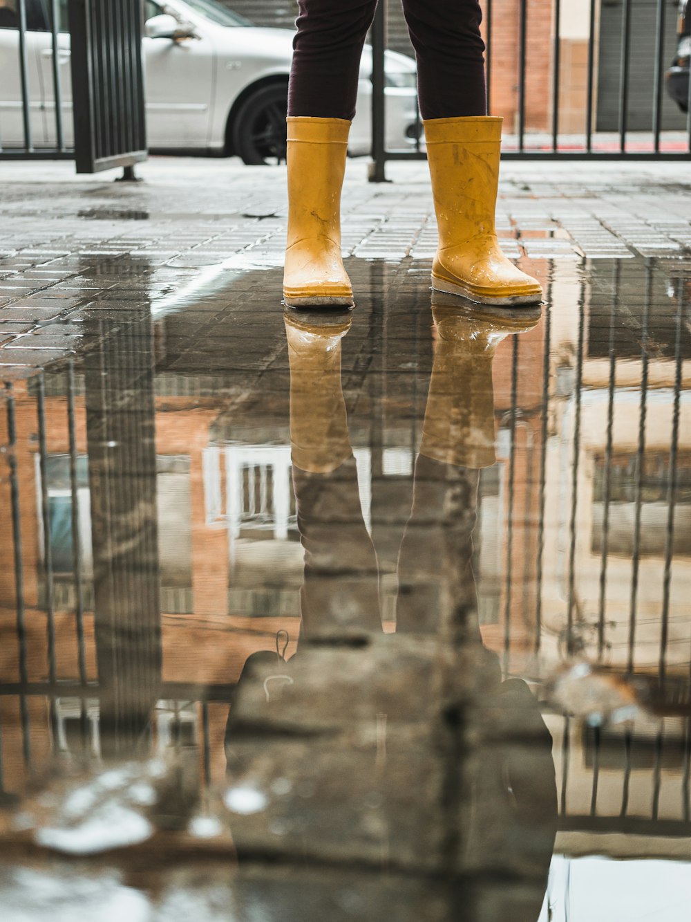a person in yellow rain boots standing in a puddle