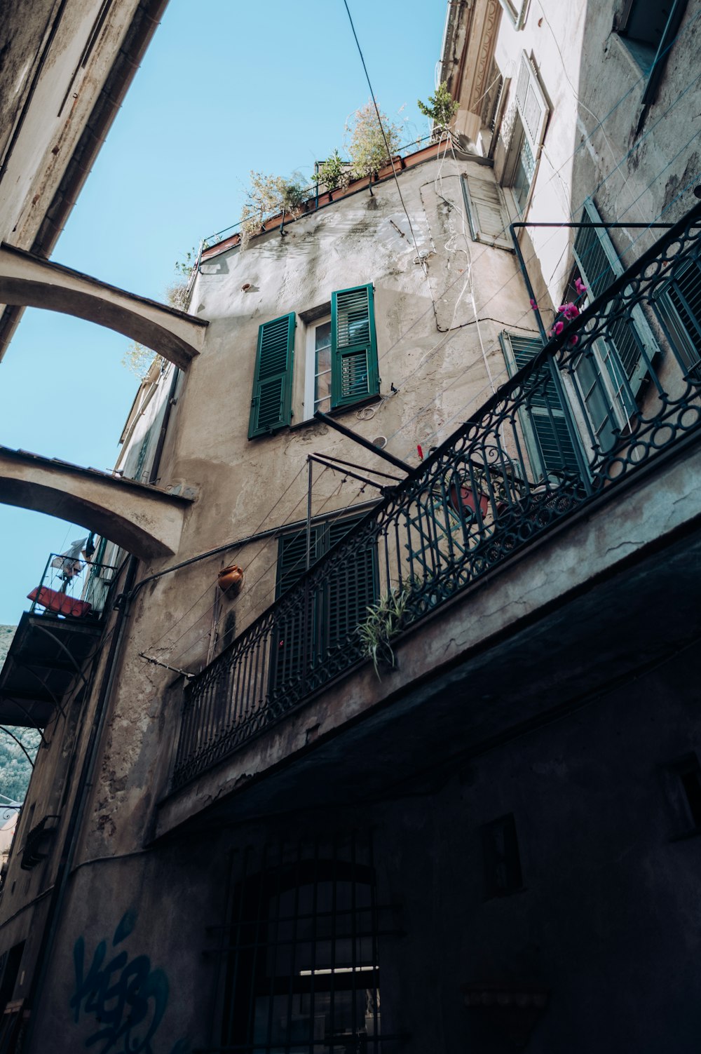 a building with green shutters and a balcony