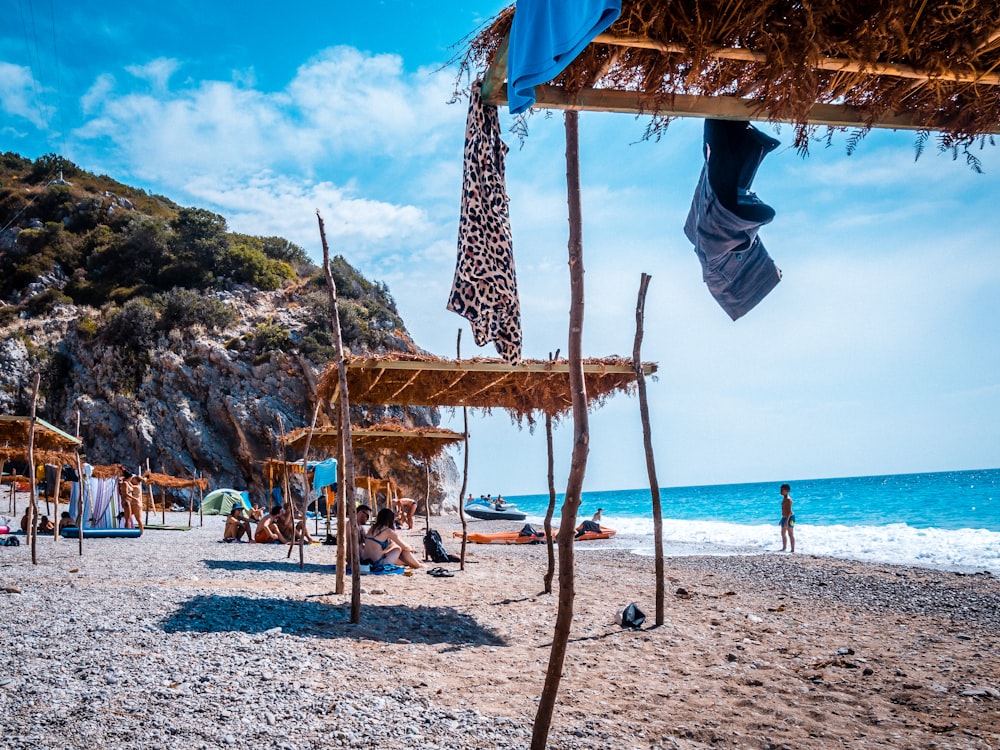 a group of people sitting on top of a sandy beach