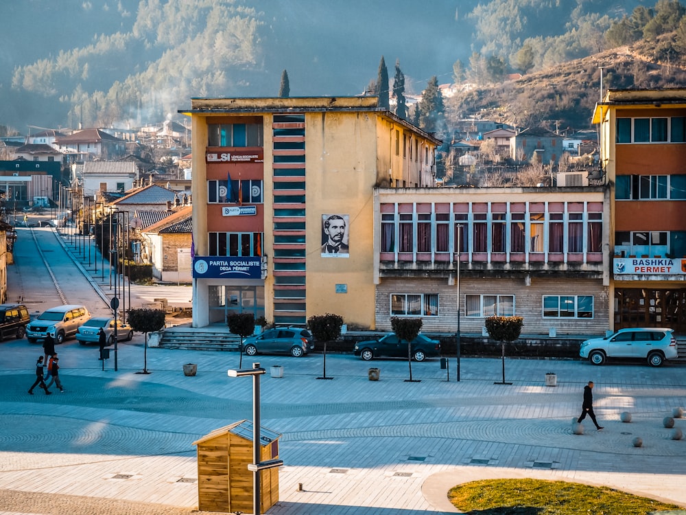 a town square with cars and people walking around