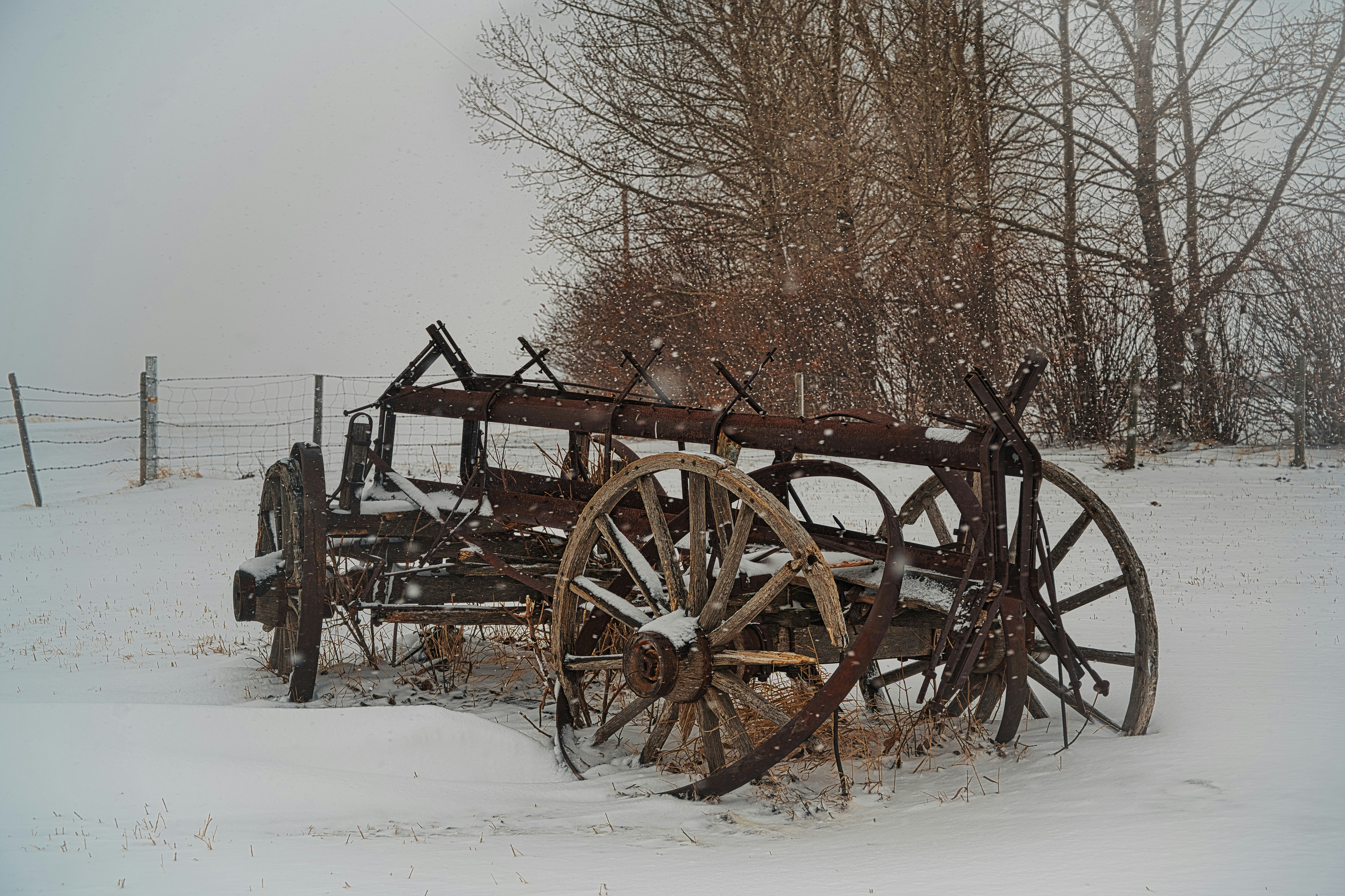 an old wooden wagon sitting in the snow