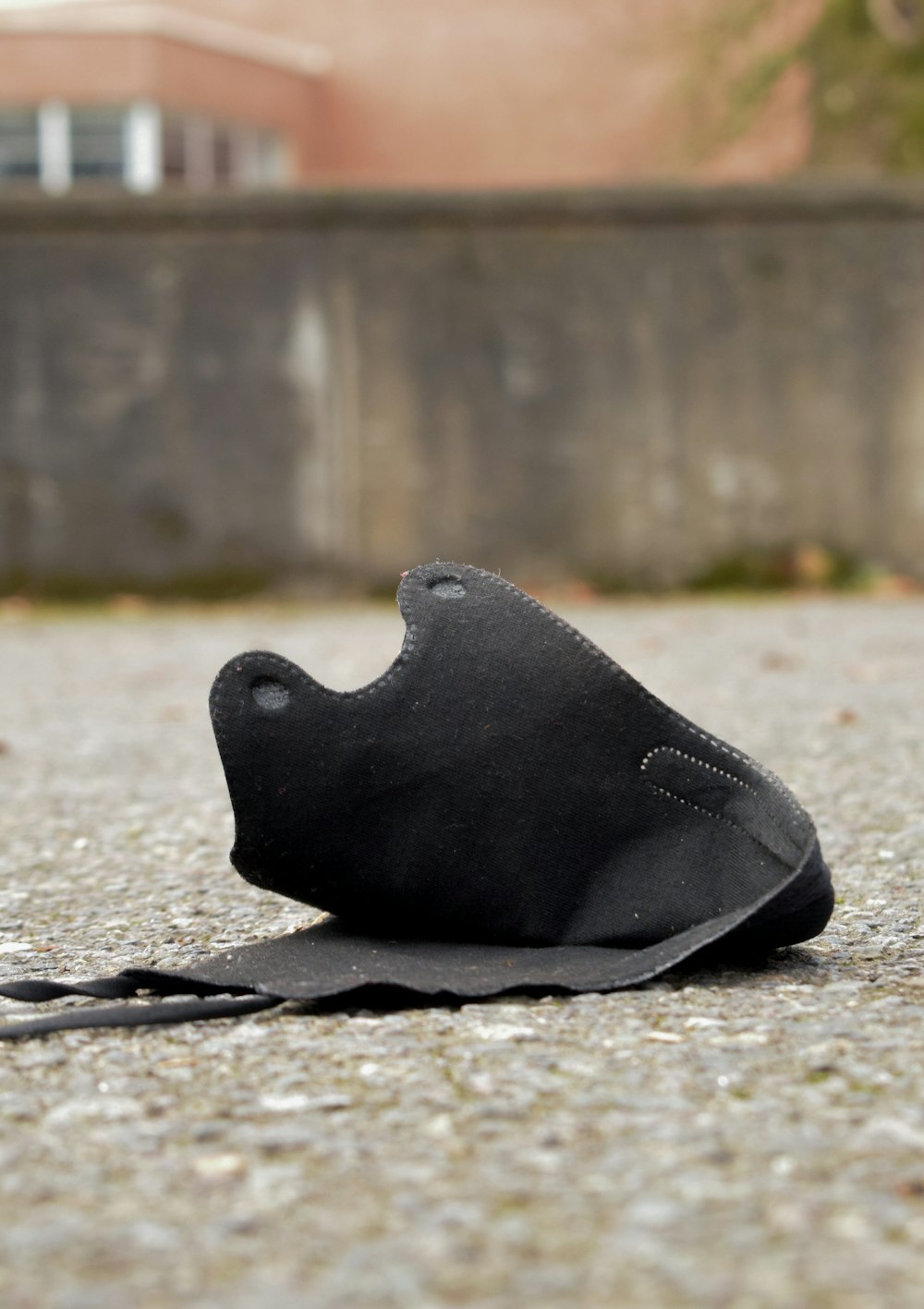 a black shoe is laying on the ground