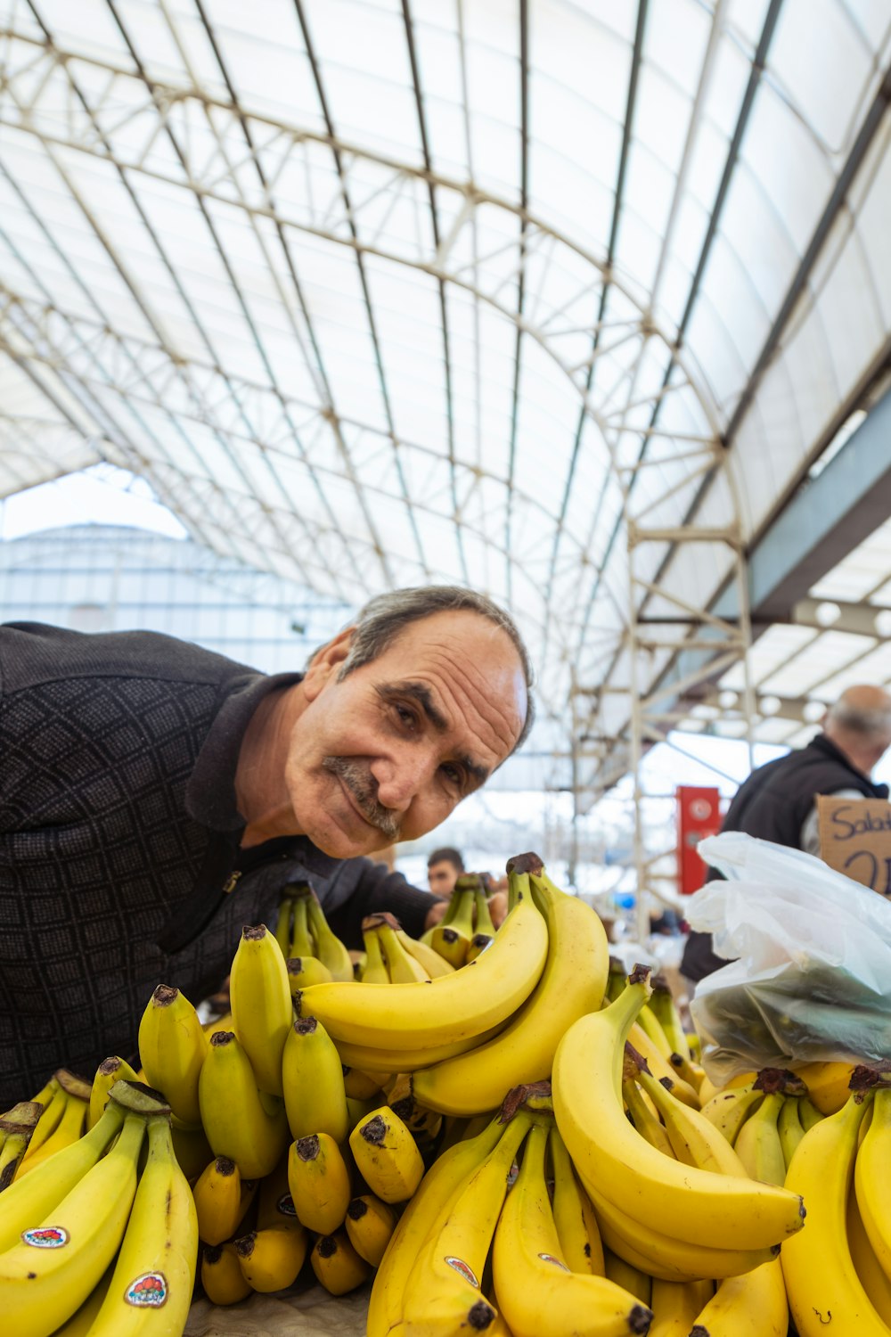 a man leaning over a pile of bananas