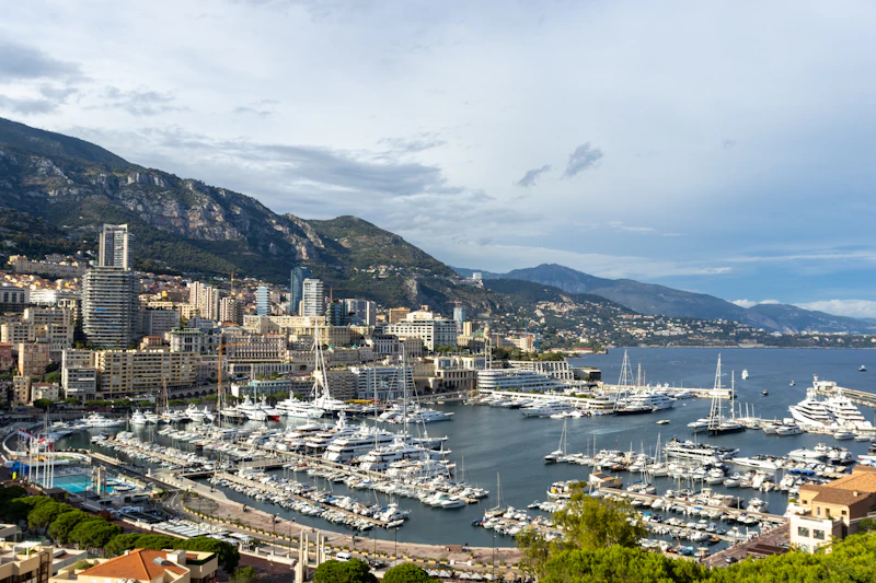 Port Hercule in Monaco, yachts moored below the city with the hills behind
