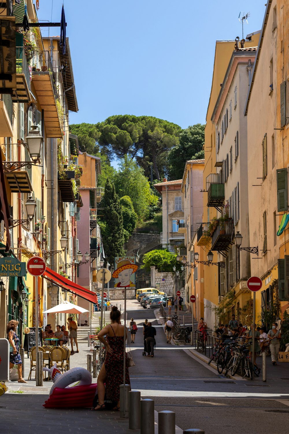 a woman sitting on a bench in the middle of a street