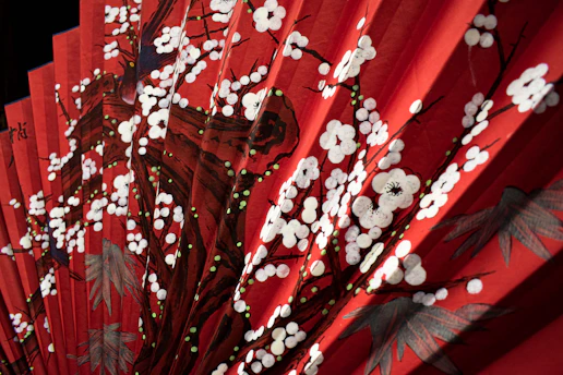 A close-up of a vibrant Brazilian folding fan with intricate patterns and bold colors, resting on a rustic wooden table.