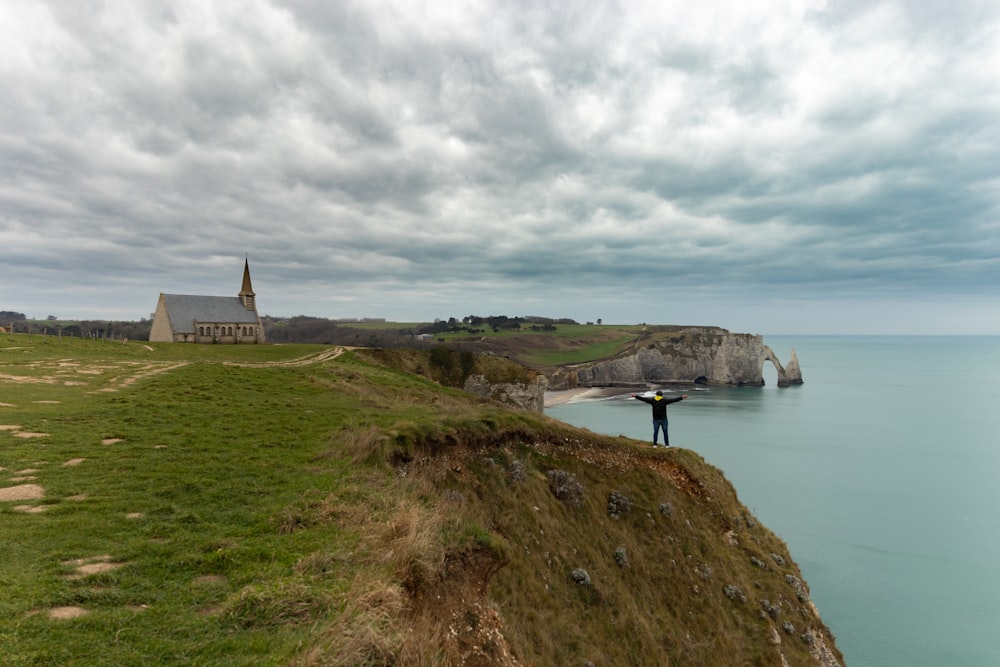 a person standing on a cliff overlooking the ocean