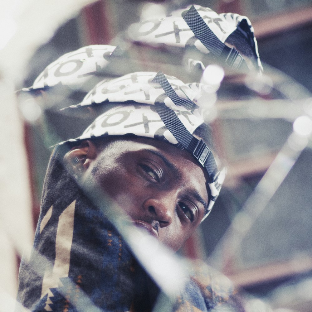 a man wearing a hat looking through a window