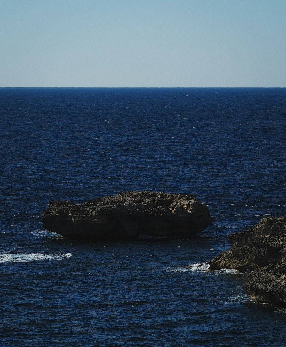 a large rock out in the middle of the ocean