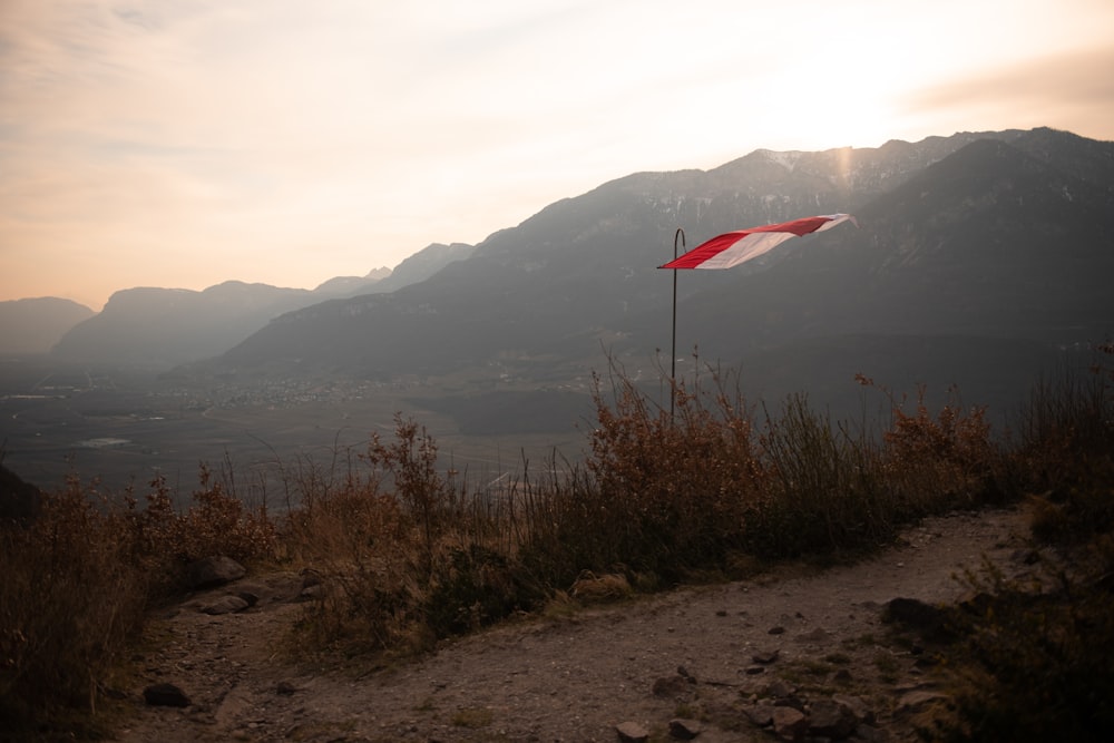 a red and white flag on top of a hill