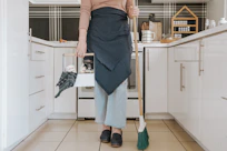 A cheerful cleaner wiping down a sparkling kitchen countertop in a cozy home