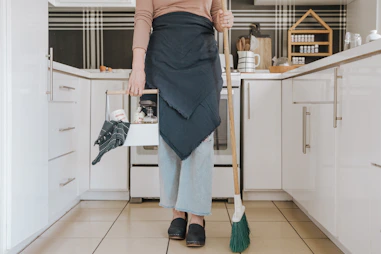 A cheerful cleaner wiping down a sparkling kitchen countertop in a cozy home