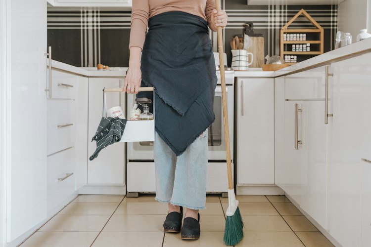 A professional cleaner mopping a bright, tidy kitchen floor