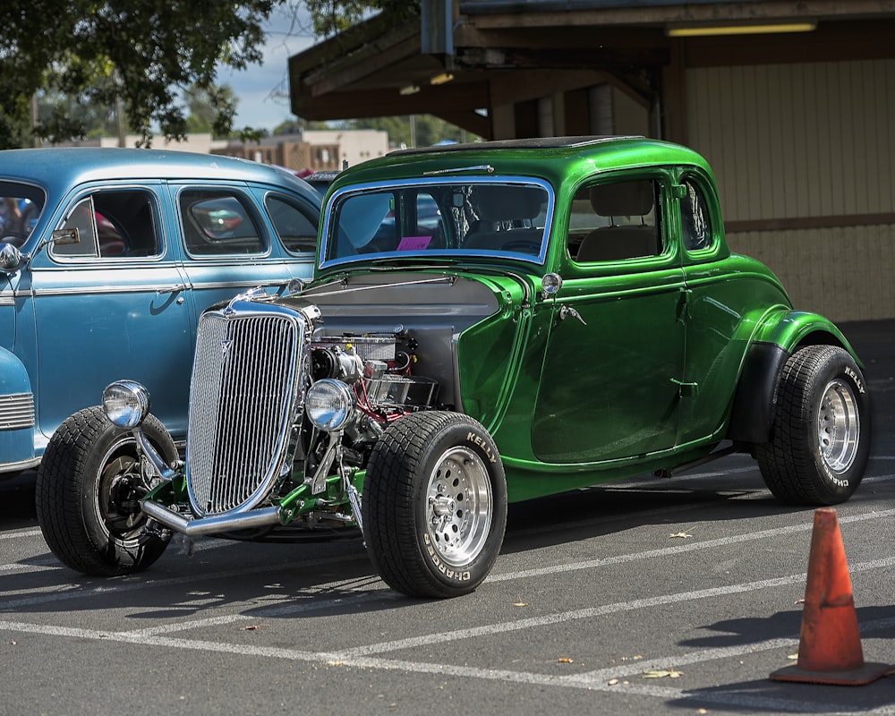 a green car parked next to a blue car in a parking lot