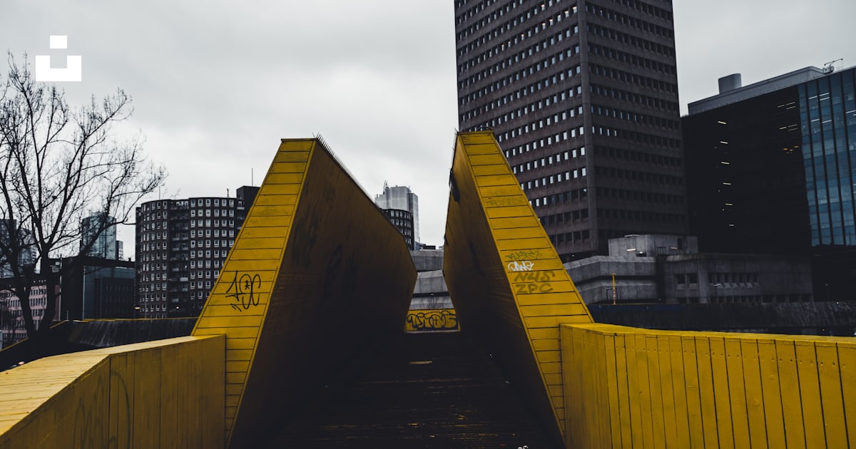 A very tall building next to a yellow ramp photo – Free Architecture ...