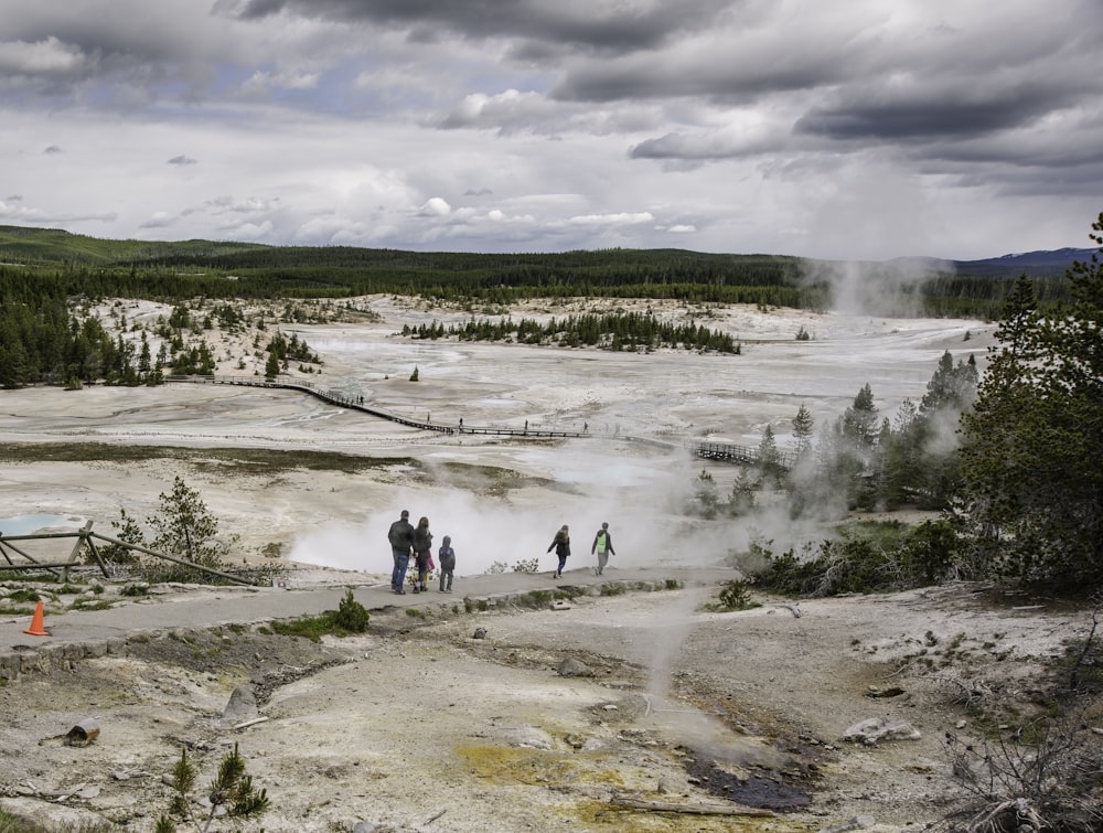 a group of people standing in front of a geyser