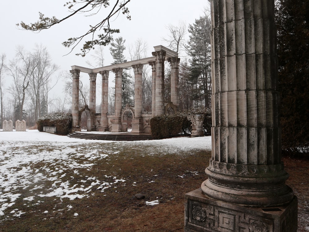 an old building with columns and a snow covered ground