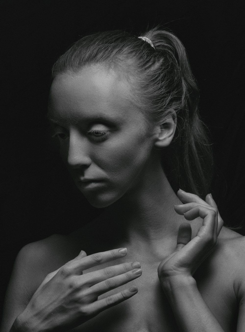 a black and white photo of a woman with her hands on her chest