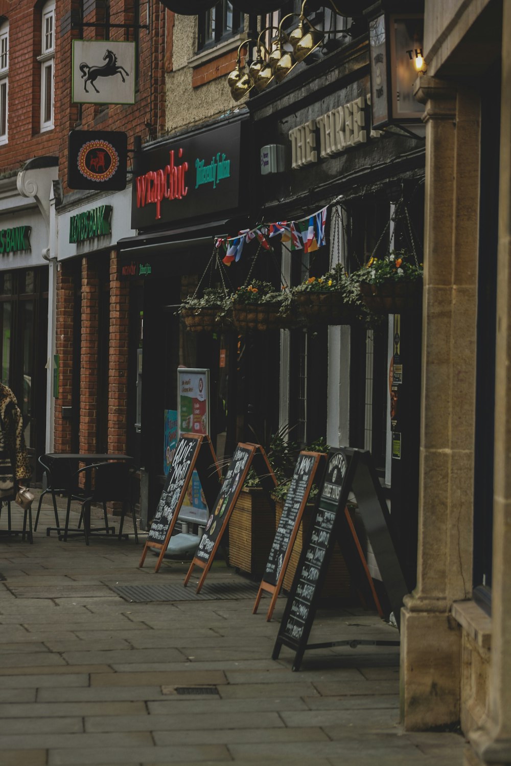 a city street with a row of shops on the side of it