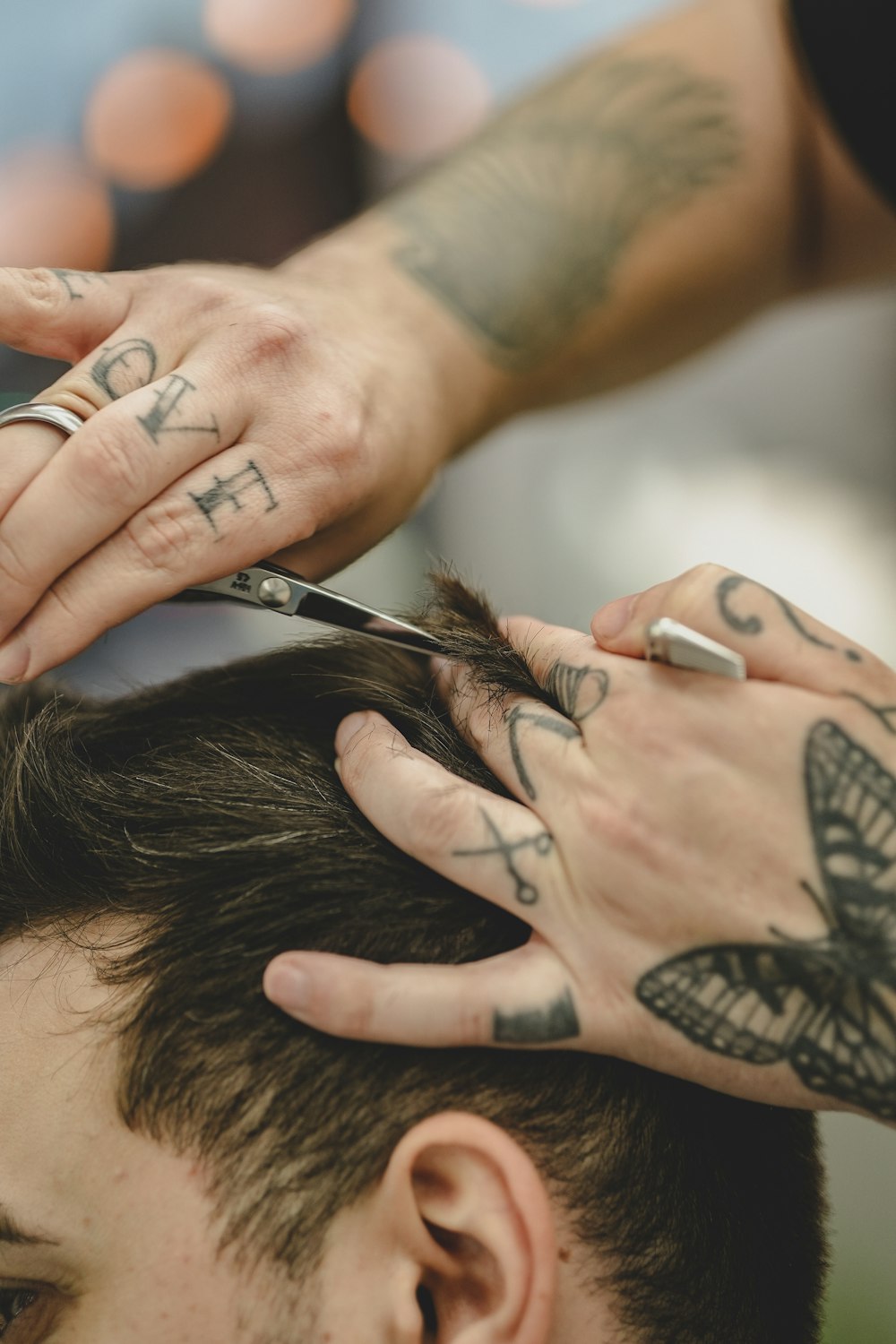 a man cutting another mans hair with scissors