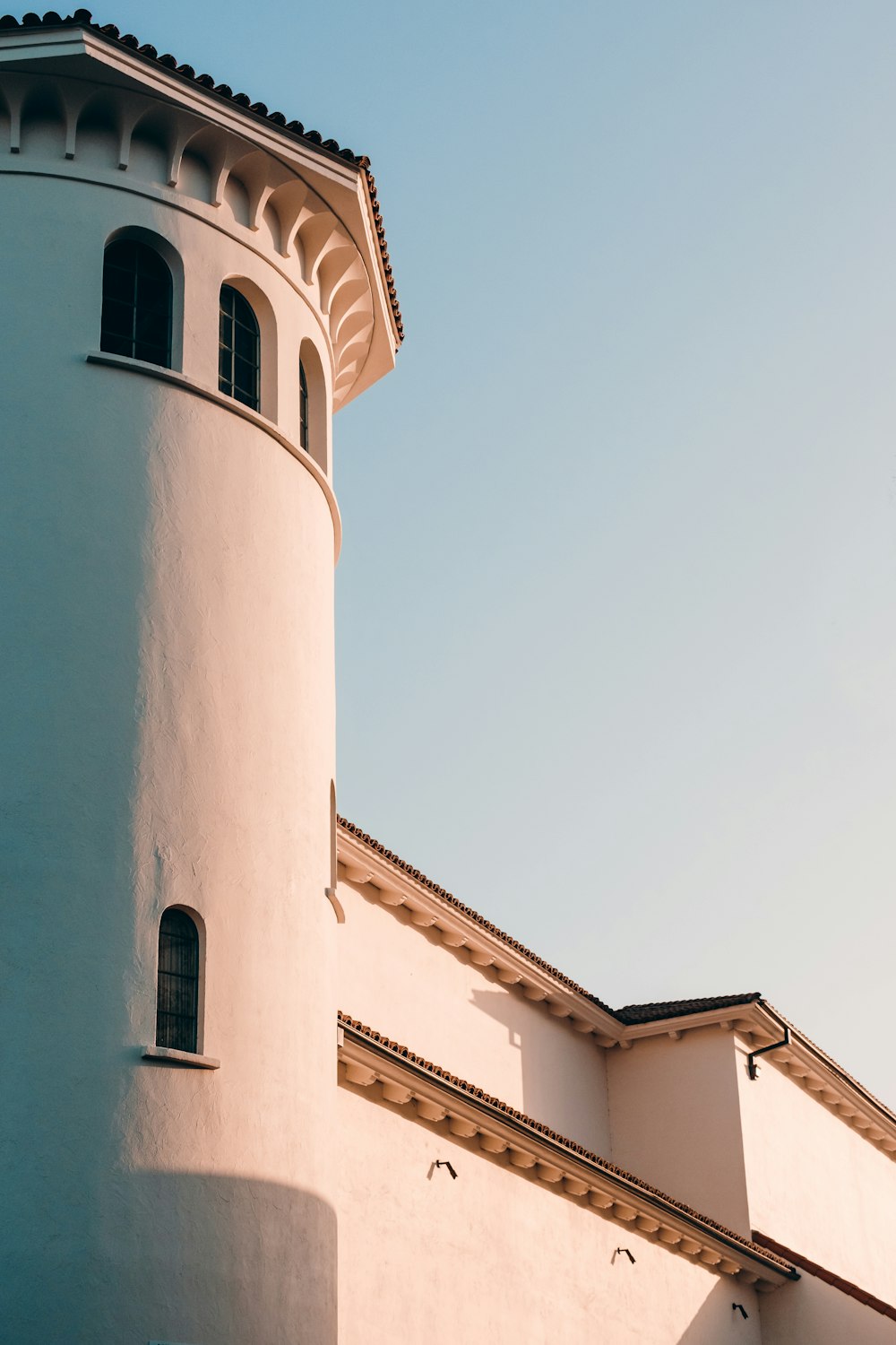 a tall white building with a clock on it's side