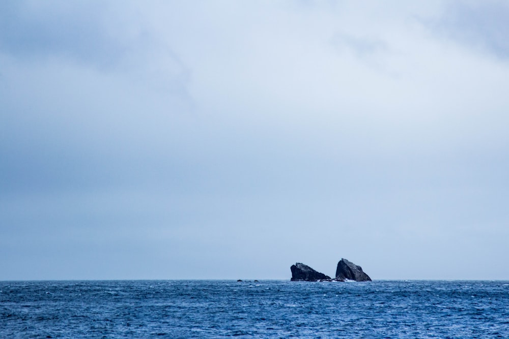 a large rock in the middle of the ocean