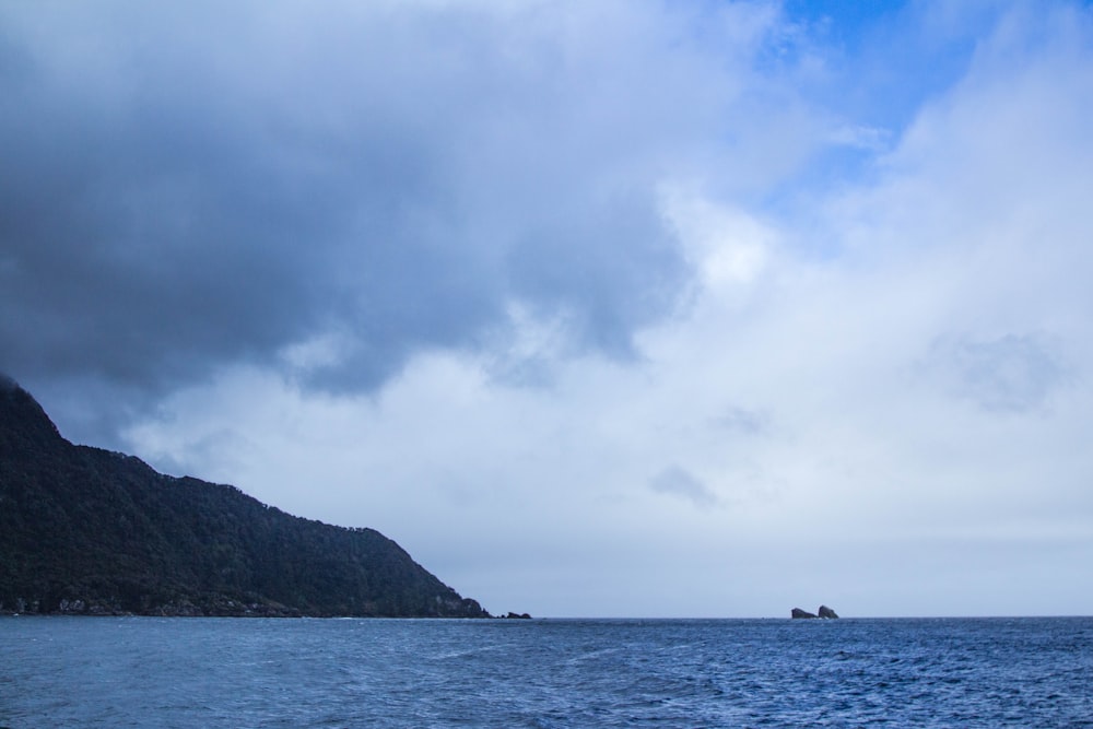 a large body of water with a mountain in the background