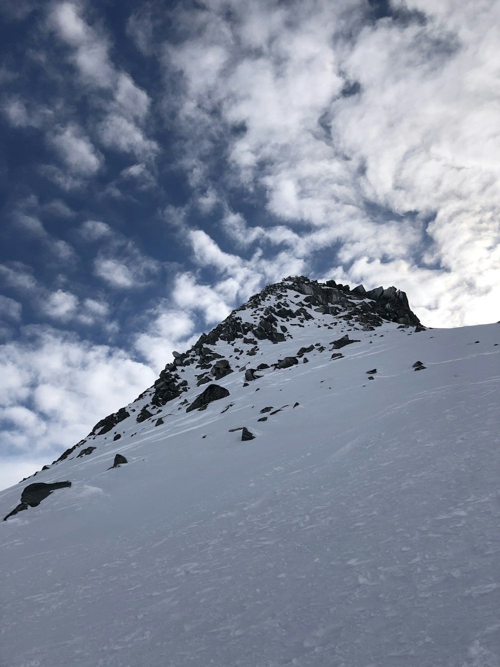 a snowboarder is going down a snowy mountain