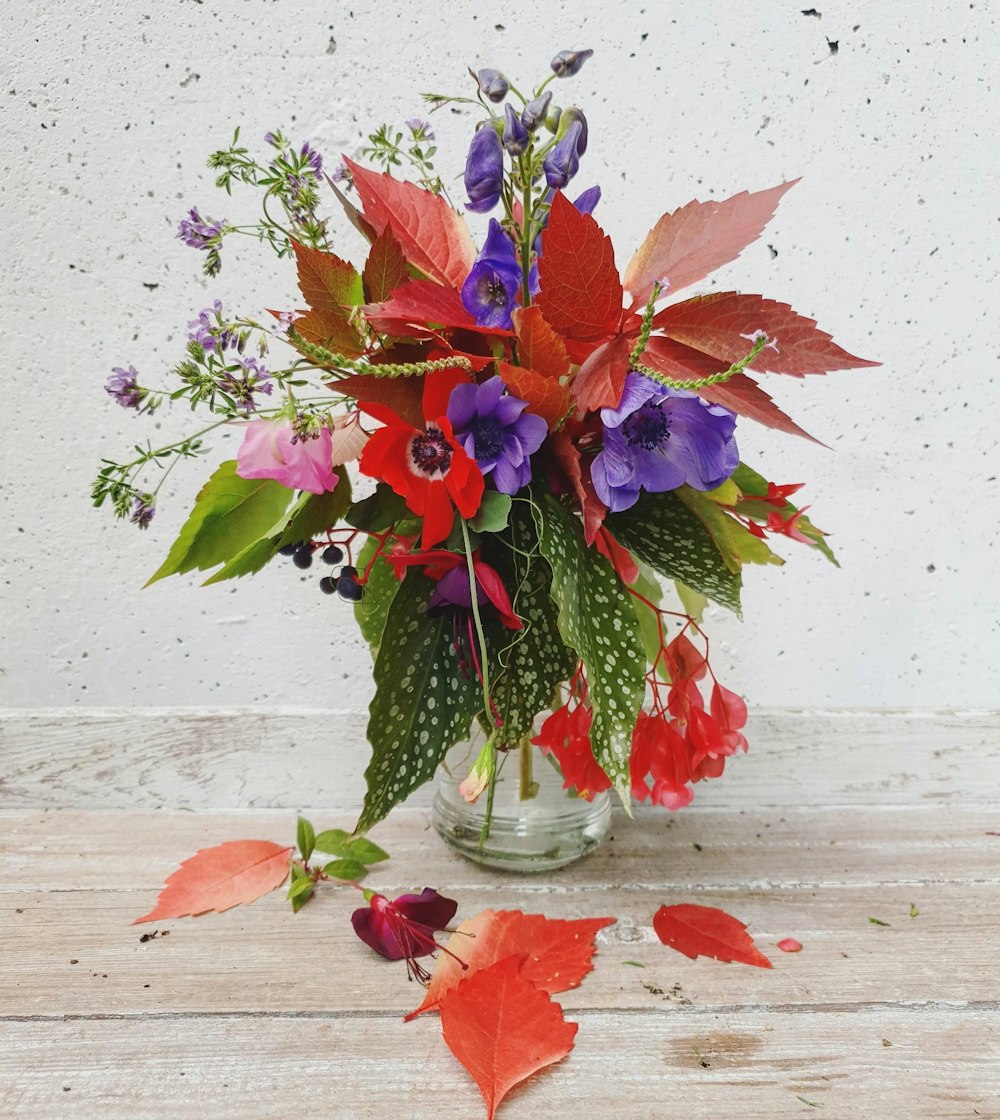 a vase filled with lots of colorful flowers