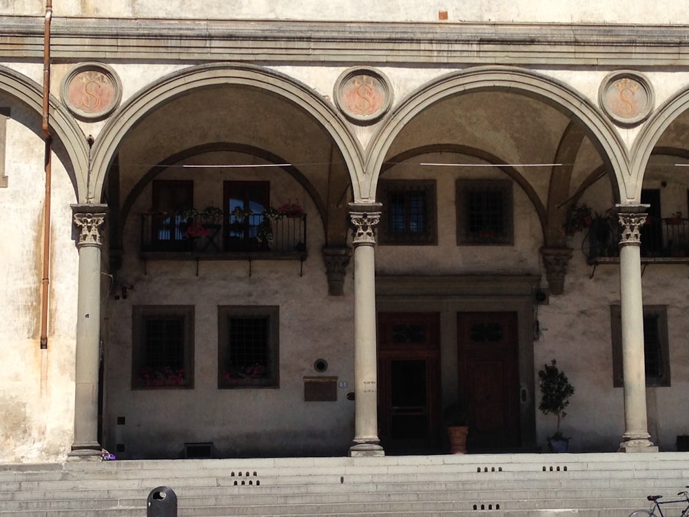 a building with arches and a clock on the front of it